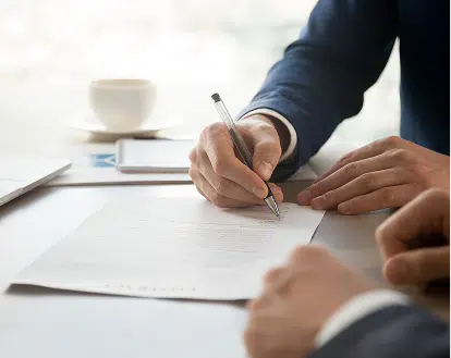 two people reviewing and signing documents