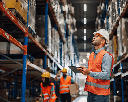 A worker with a clip board in a large warehouse