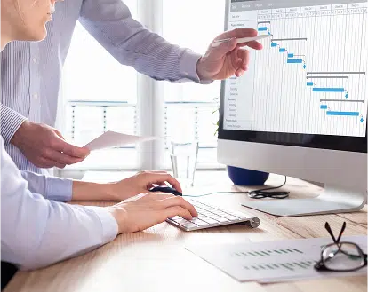 Two people reviewing a chart on a computer screen