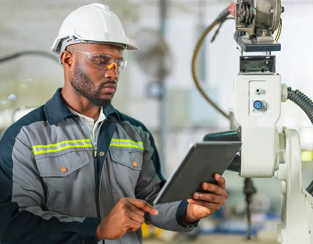 A worker with a clipboard reviewing equipment