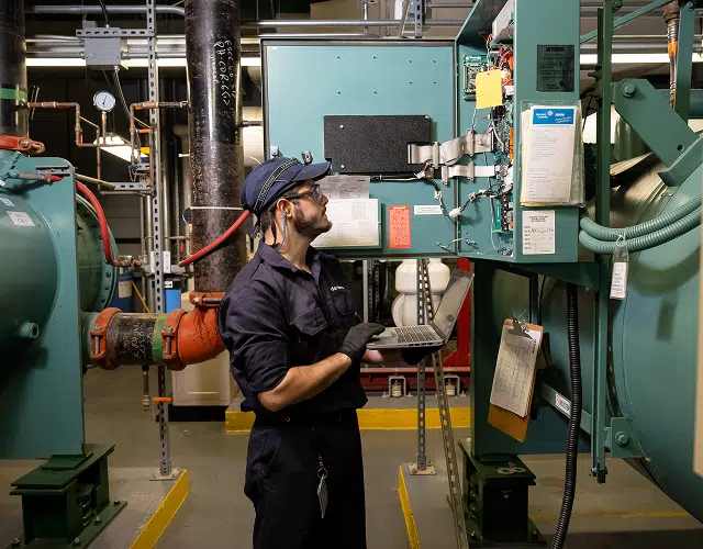 A worker looking at machinery