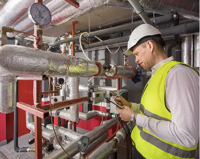 a worker reviewing an engine room
