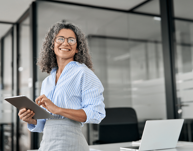A woman smiling holding a tablet