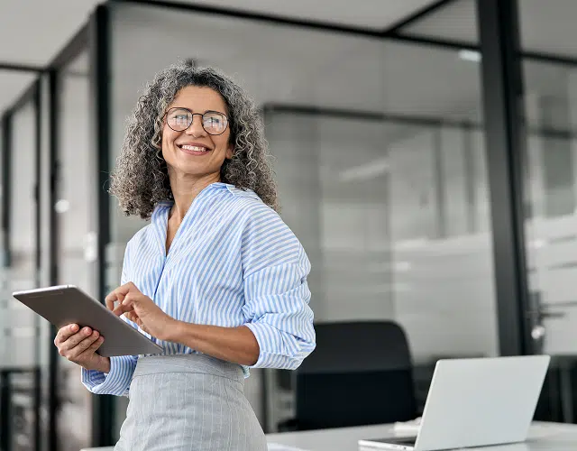 A woman smiling holding a tablet